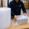 Plástico de burbuja en entorno industrial Uso industrial del plástico de burbuja 60 cm x 150 metros protegiendo paquetes en almacén logístico